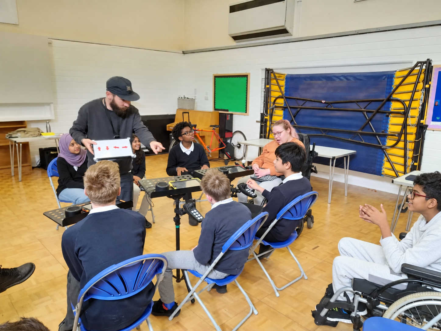 Learners using CMPSR controllers while a facilitator demonstrates an Arrownotes rhythm.